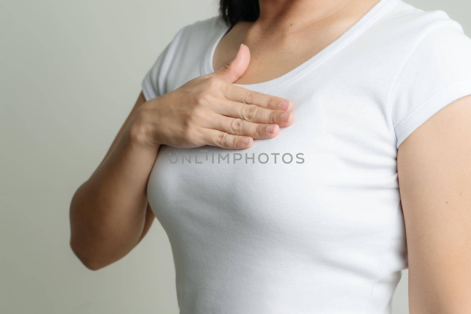 woman hand touching chest to support breast cancer cause. breast cancer awareness concept by psodaz