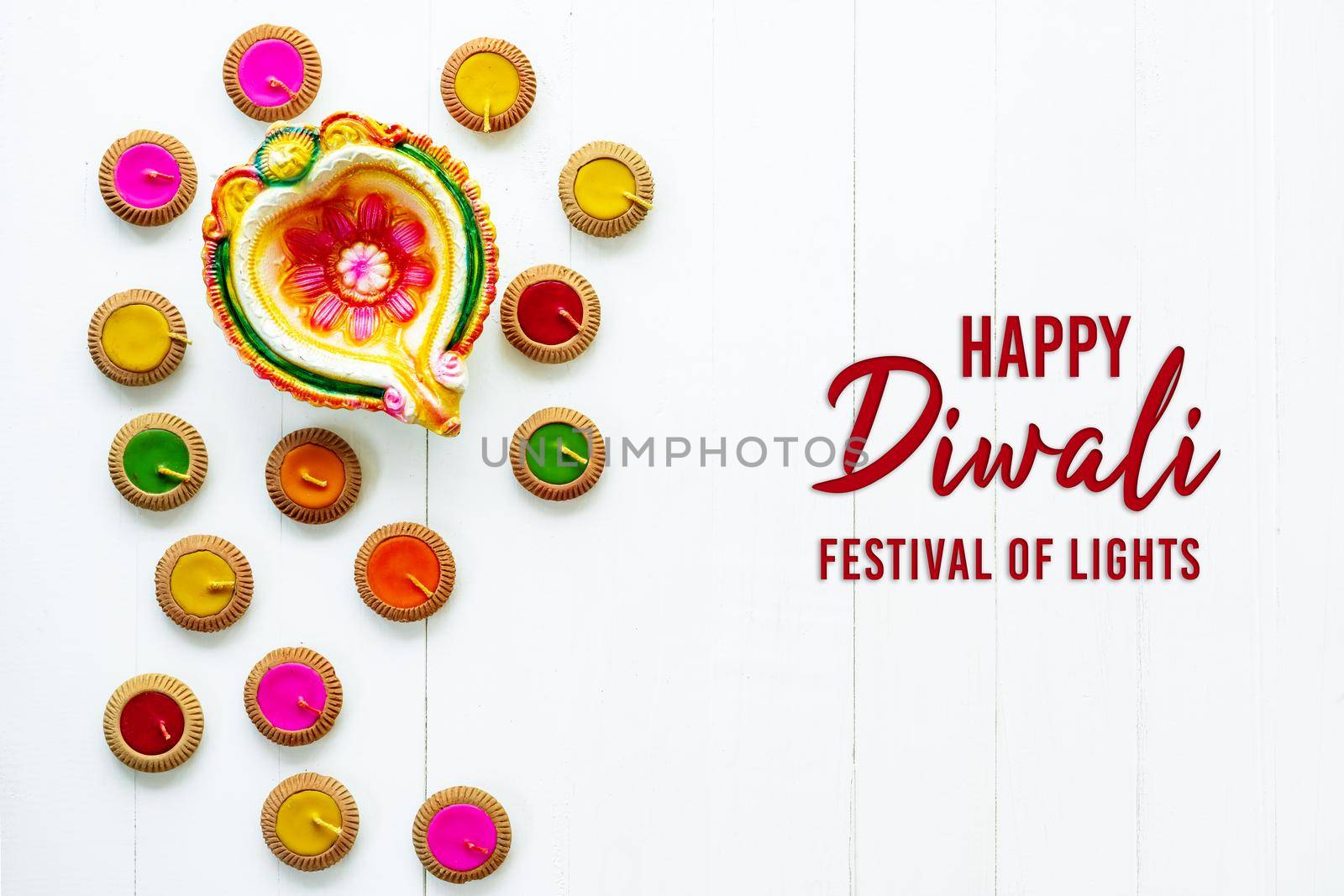 Happy Diwali - Clay Diya lamps lit during Dipavali, Hindu festival of lights celebration. Colorful traditional oil lamp diya on white wooden background