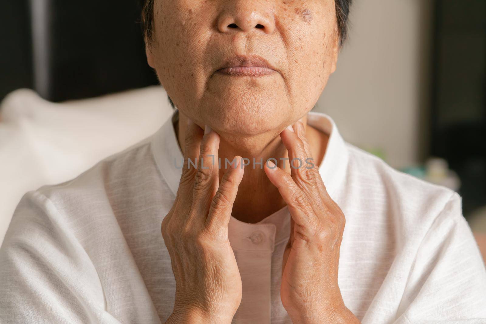 Senior adult women touching the neck feeling unwell coughing with sore throat pain.Healthcare and medicine concept by psodaz