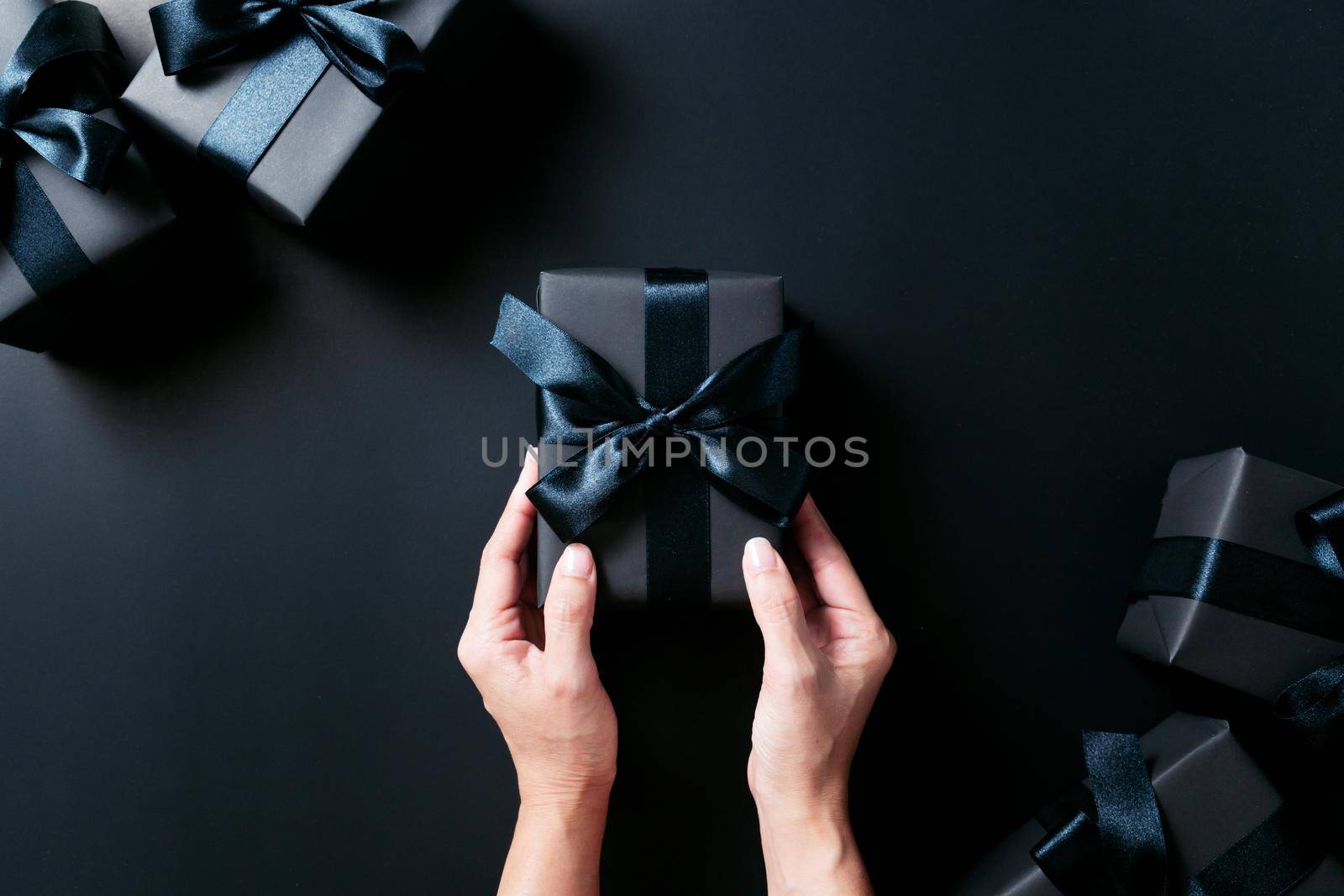 Boxing day Sale concept, woman hand give the gift box on black background by psodaz