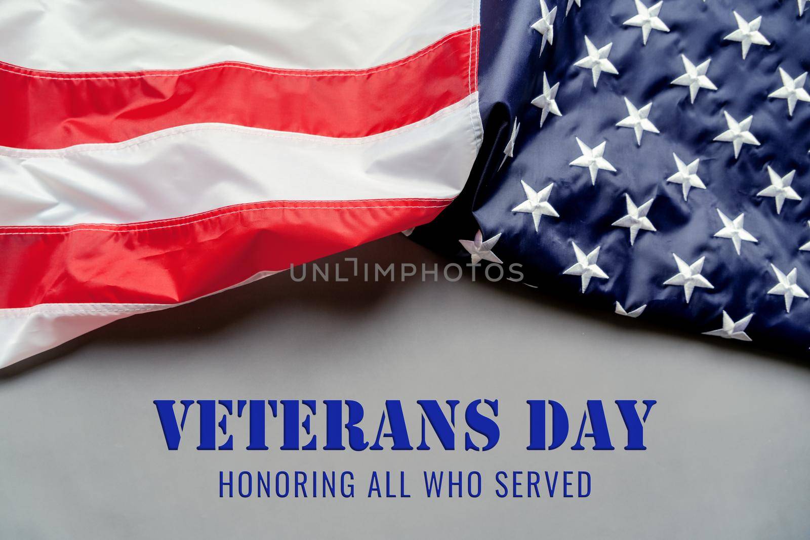 Veterans day. Honoring all who served. American flag on gray background with copy space.