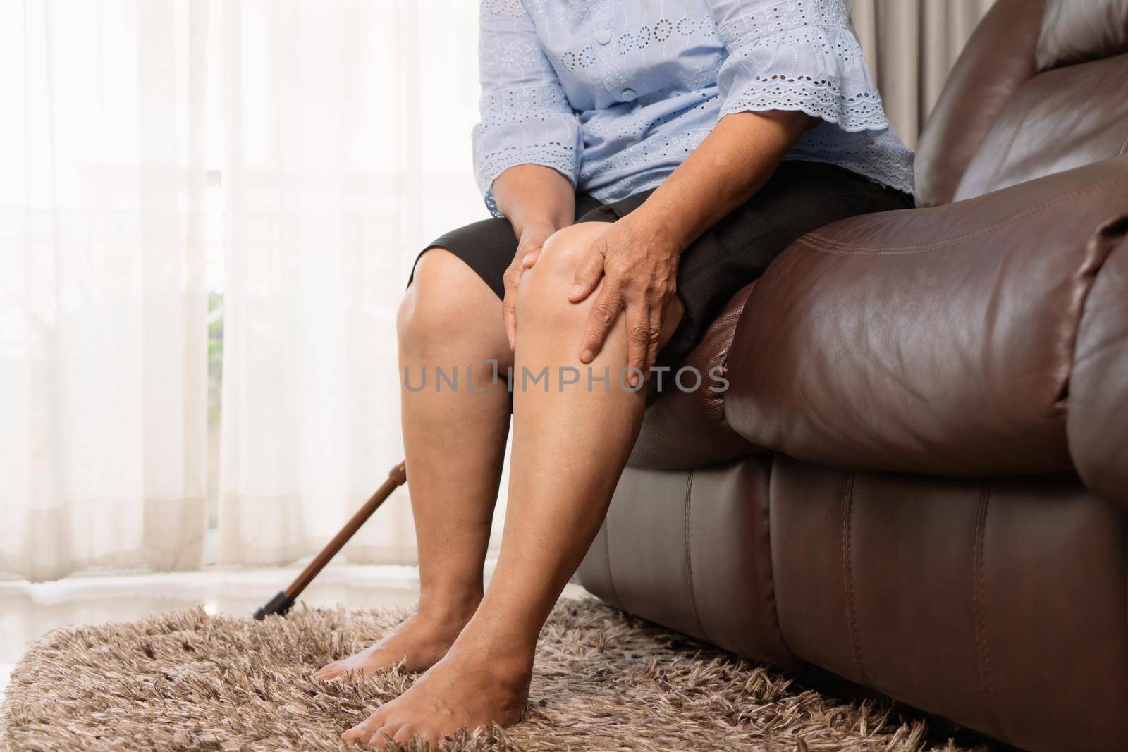 senior woman suffering from knee pain at home, health problem concept by psodaz