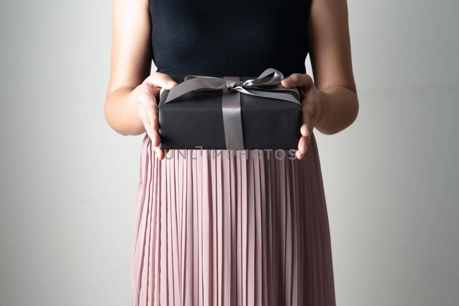 Boxing Day sale, young woman hold a gift box offer to receiver by psodaz
