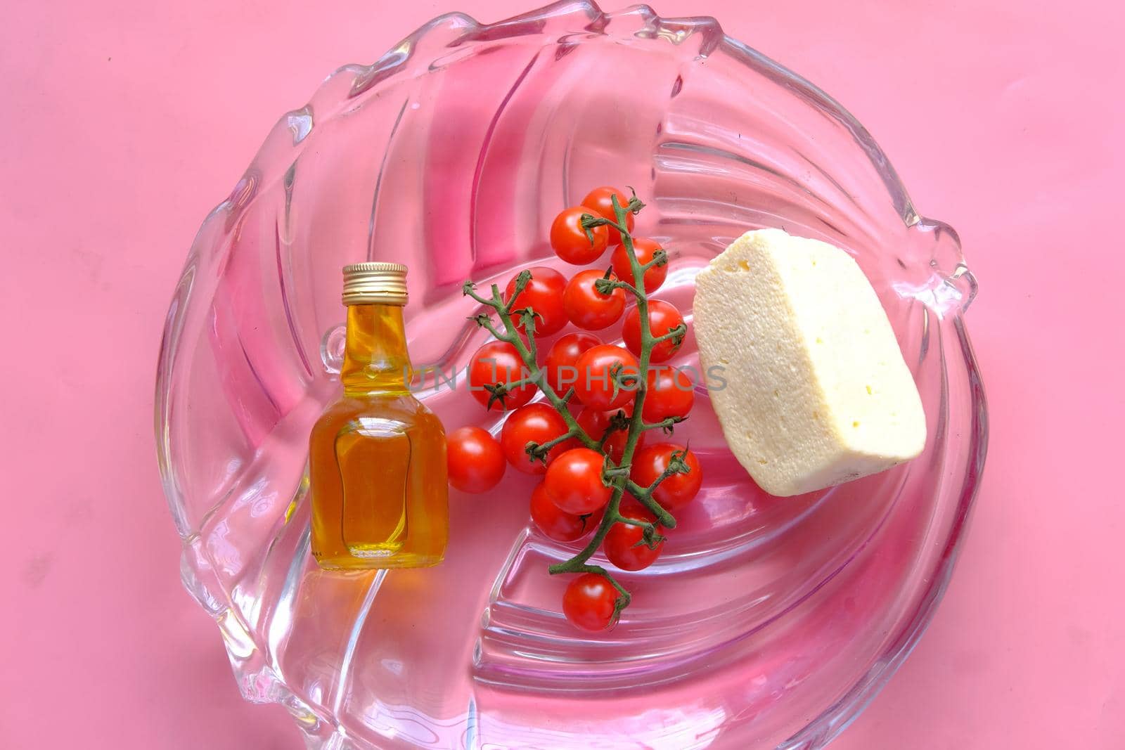 cherry tomato, cheese and olive oil on table .