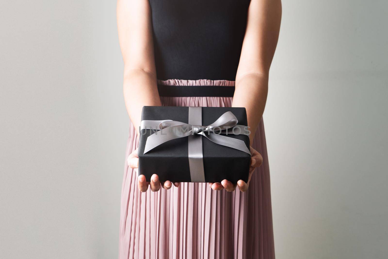 Boxing Day sale, young woman hold a gift box offer to receiver by psodaz