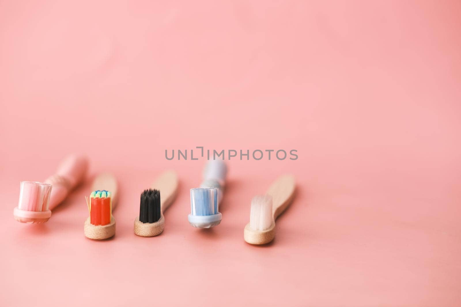 colorful toothbrushes on pink background with copy space ,