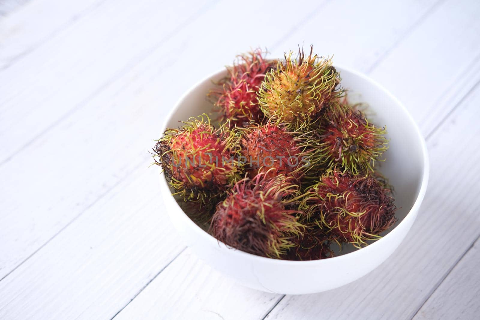 stack of rambutan in a bowl on table ,