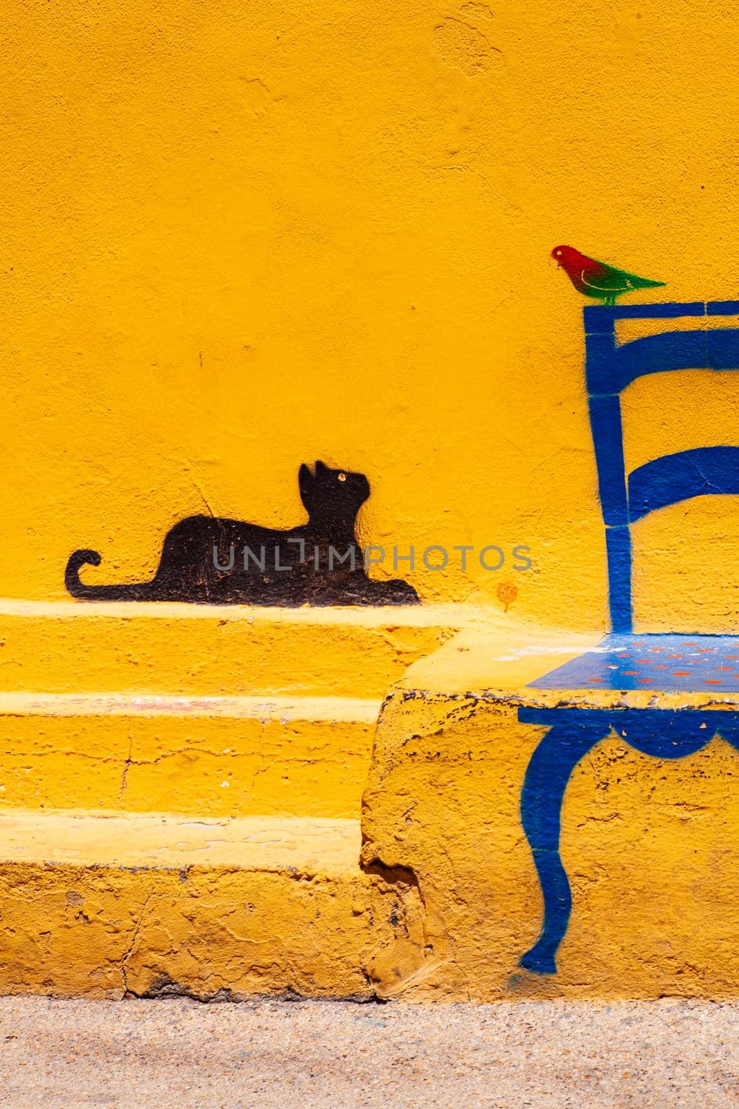 Famous Illustration on Linosa's wall of a cat looking at a bird sitting on a chair, Pelagie island. Sicily