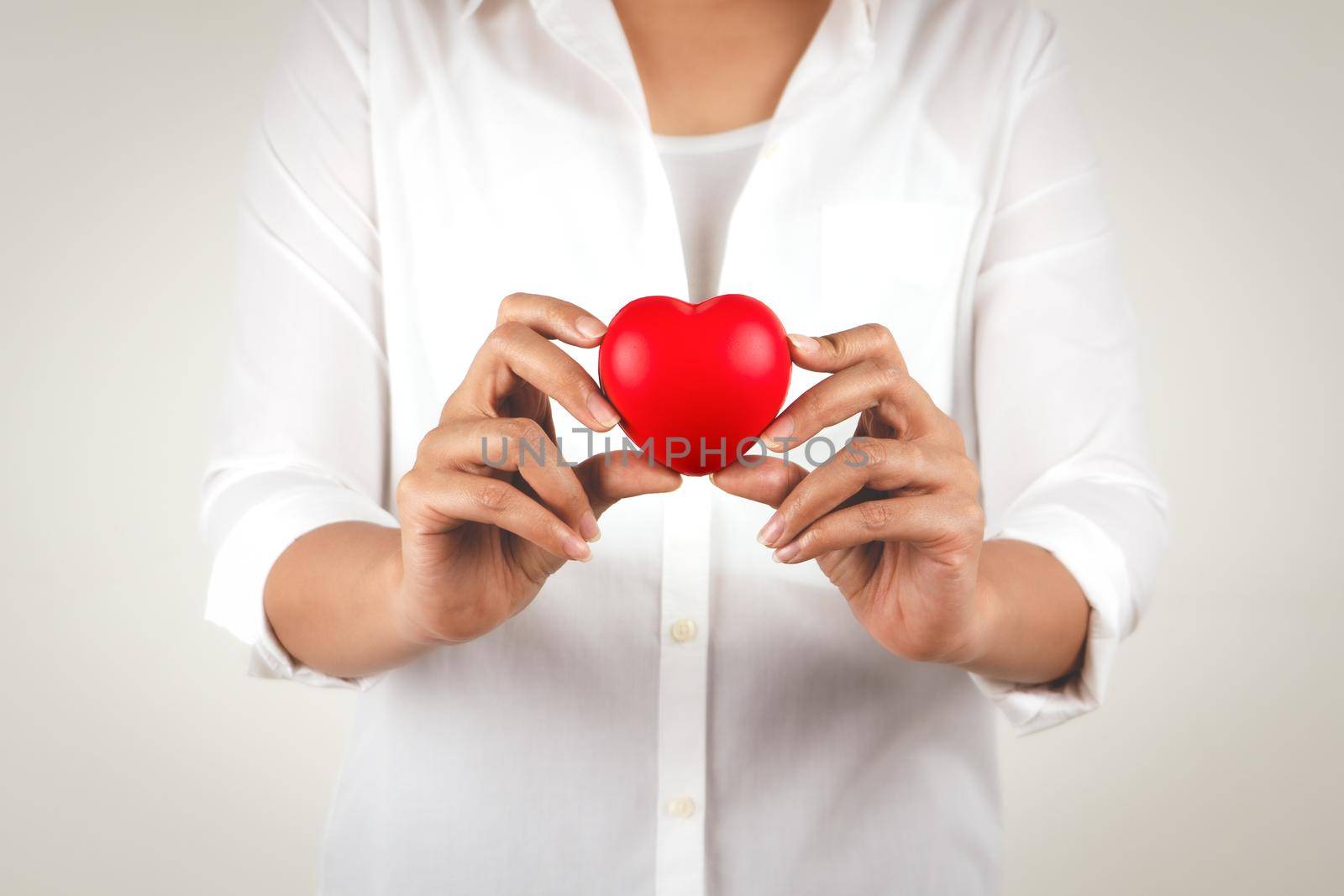 Healthcare concept of young woman hand holding red heart