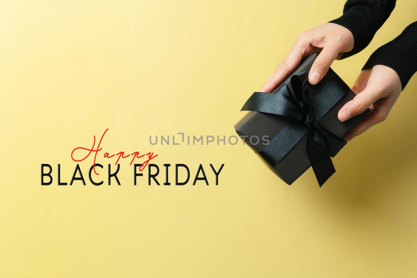 black friday sale, woman hand give the gift box on yellow background