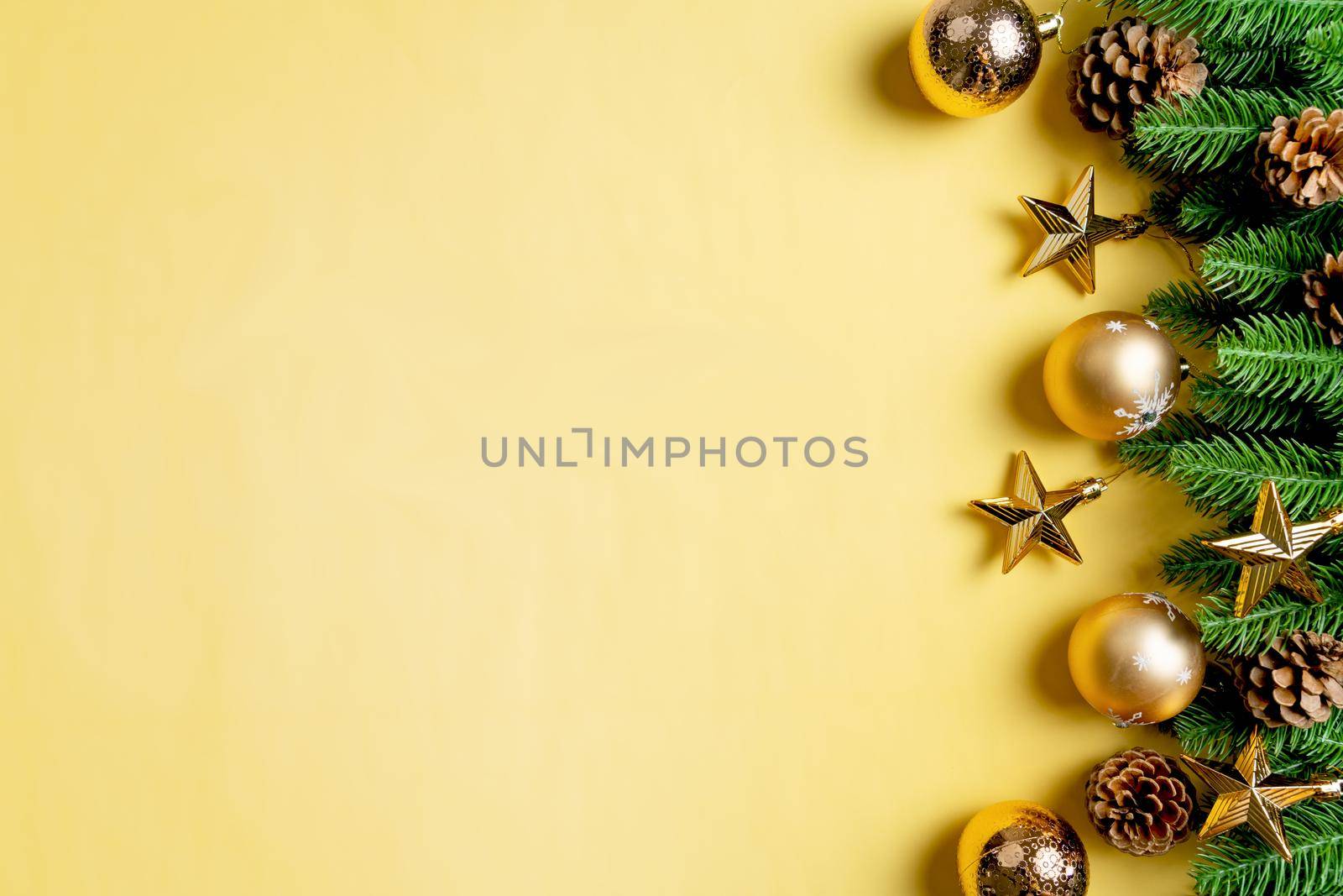 Christmas ball and pine tree with xmas decoration on yellow background