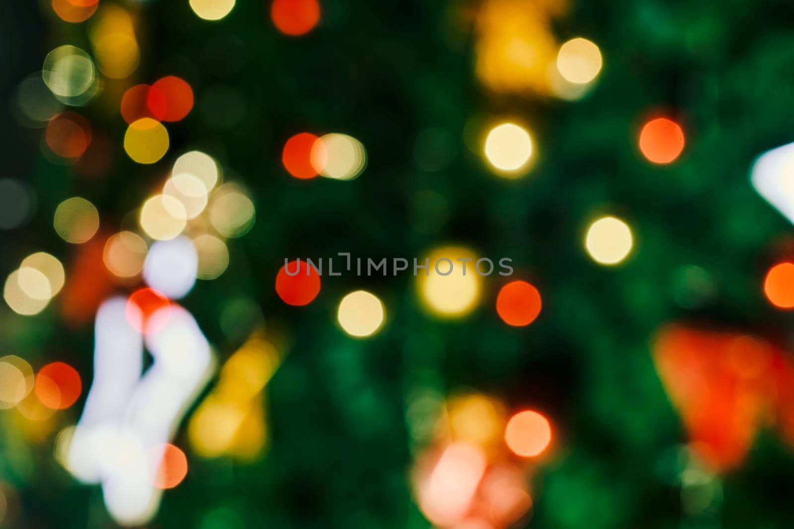 Blurred image of festive Christmas tree with decorations. Defocused christmas background. Merry Christmas background. Closeup shot of Christmas tree with Xmas decorations
