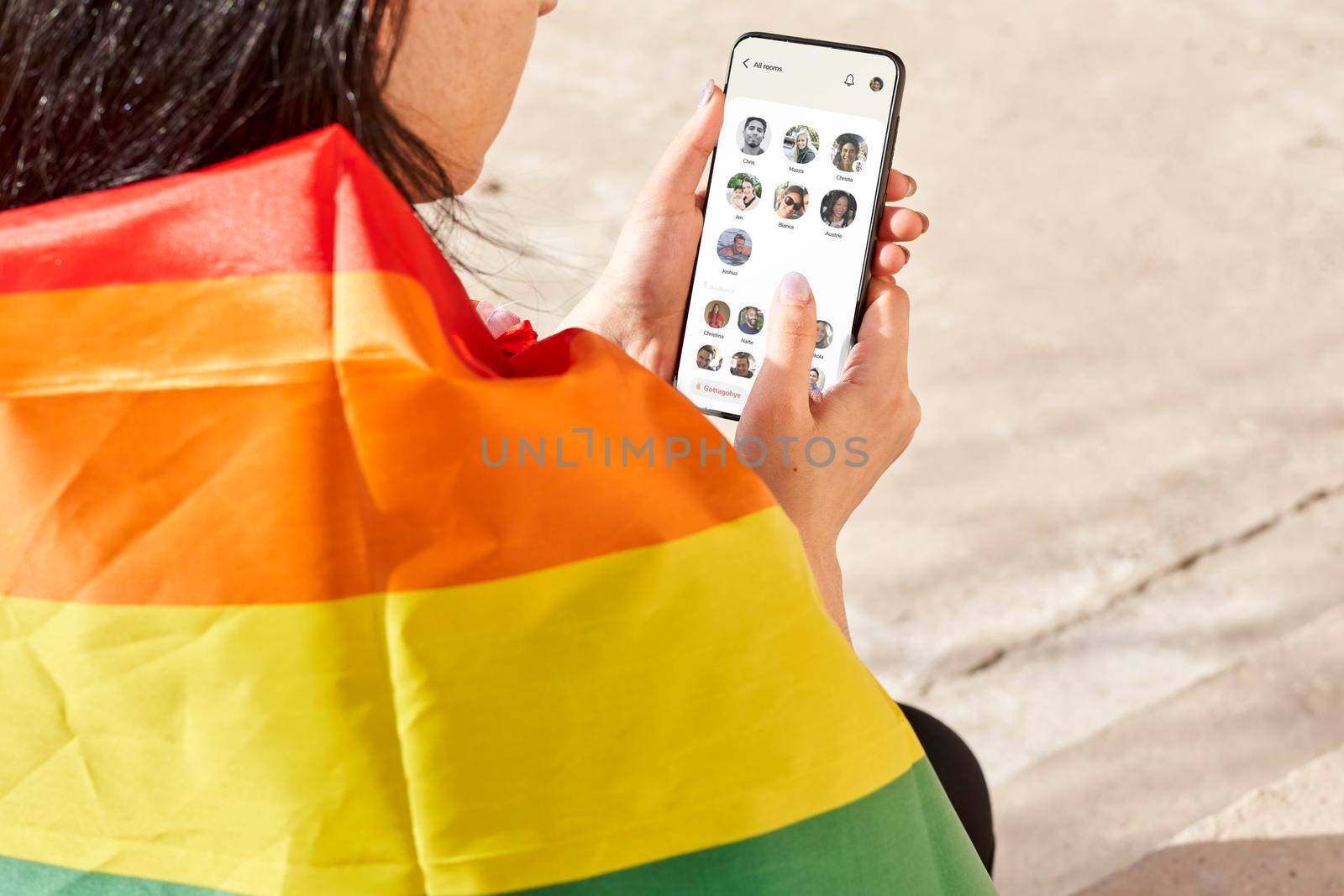Tashkent, Uzbekistan - 15 February, 2021: A female with rainbow flag using famous clubhouse application on iPhone