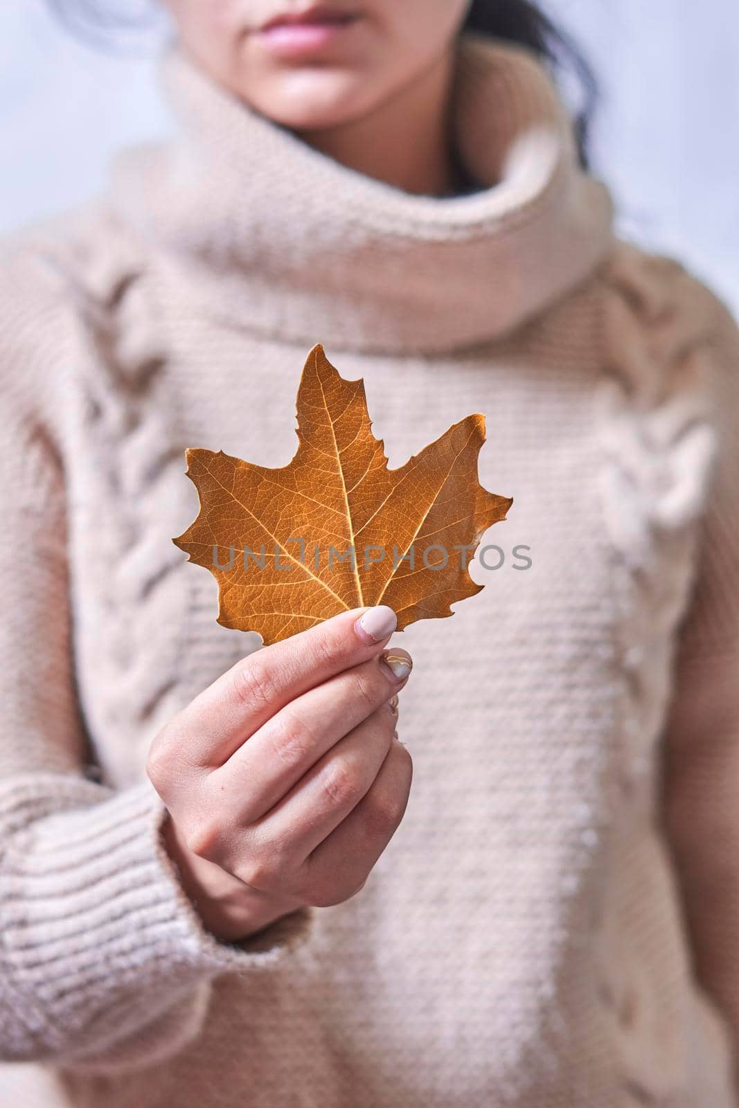 Woman holds in hand a fall leaf by golibtolibov