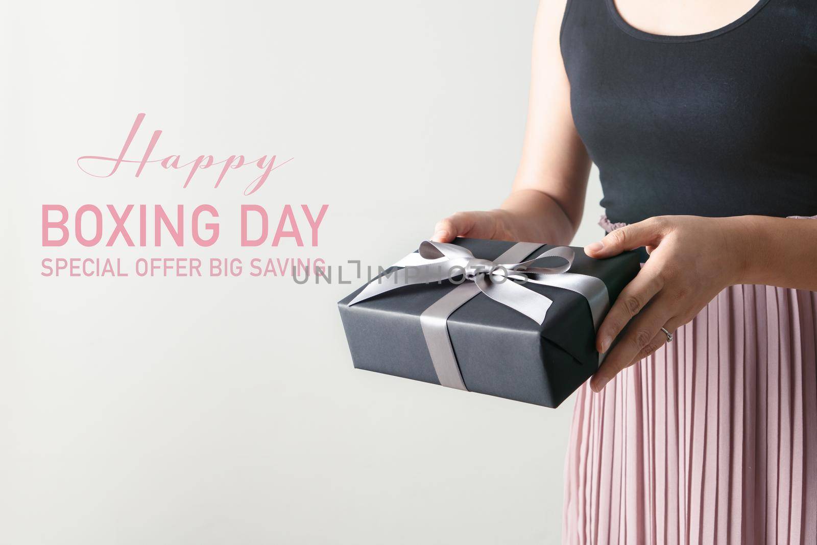 Boxing Day sale, young woman hold a gift box offer to receiver