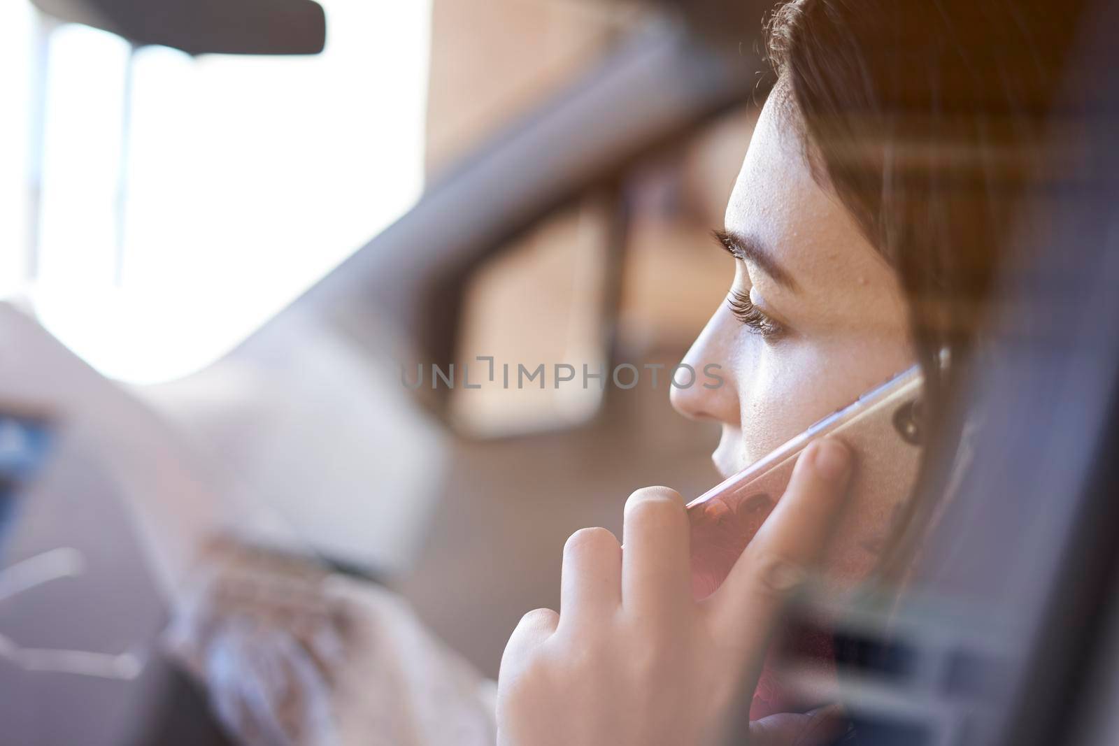 Unsafe driving. Young multiracial woman talking on the phone while driving. Distracted Driving. Female driving and talking on cellphone