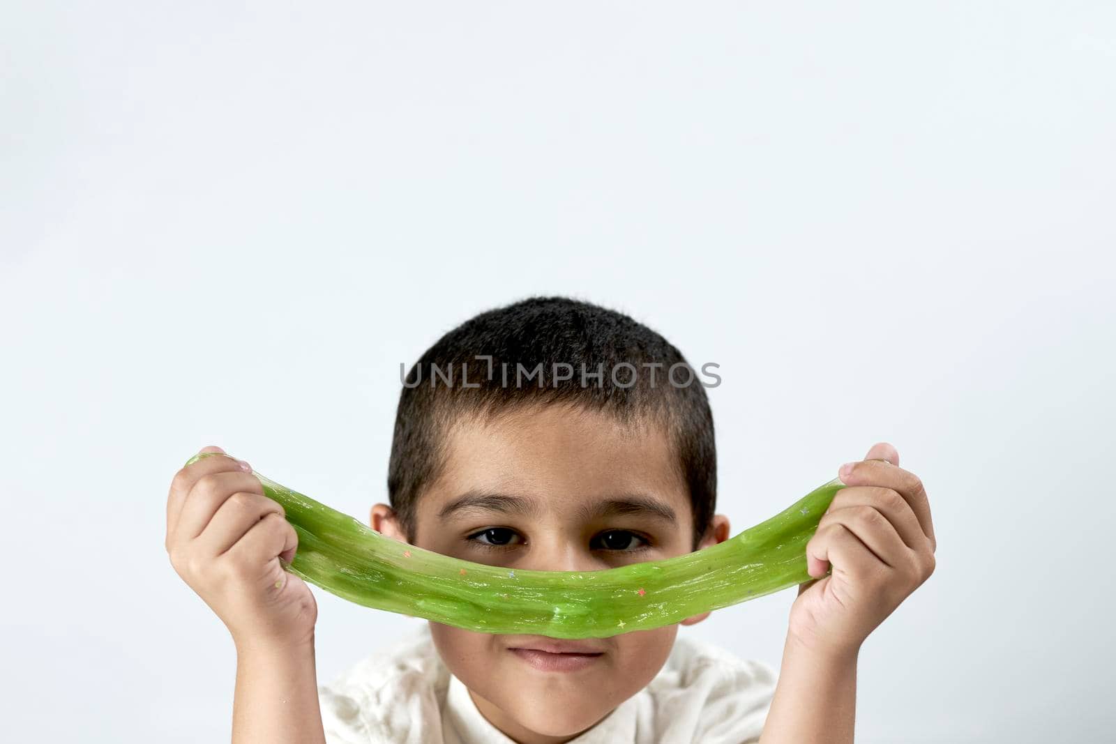 Portrait of cute boy covering mouth with slime by golibtolibov