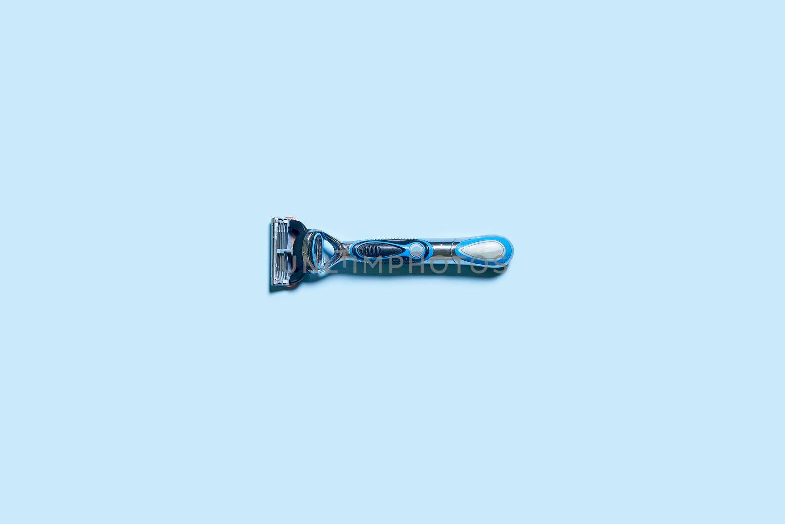 Mens shaving razor. A multiple use shaving razor on blue background. View from above
