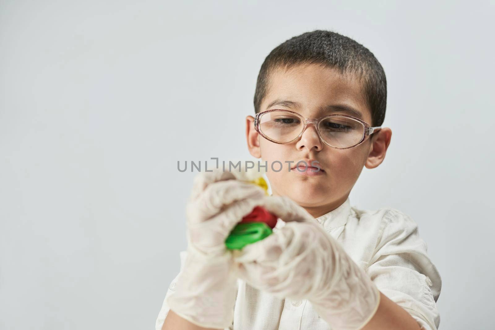 Little boy scientist in white making experiments by golibtolibov