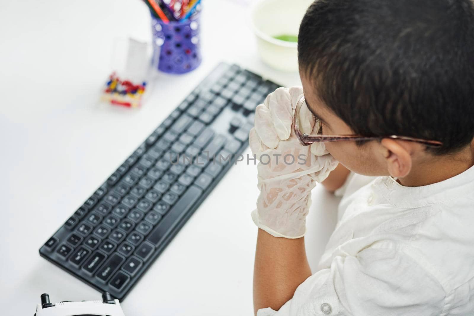 Rearview of a child sitting on the table and doing homework