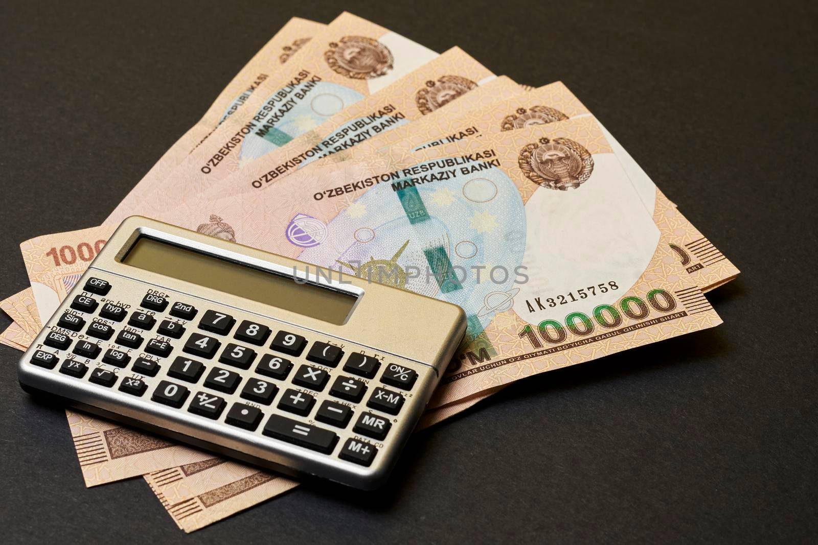 Uzbek money and calculator on black by golibtolibov