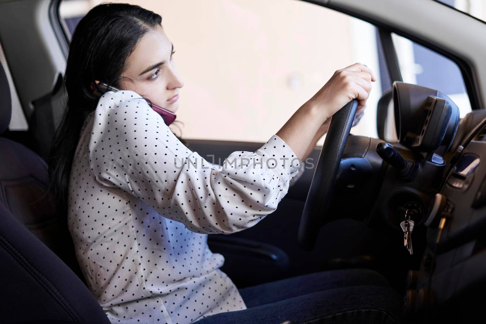 Unsafe driving. Young multiracial woman talking on the phone while driving. Distracted Driving. Female driving and talking on cellphone