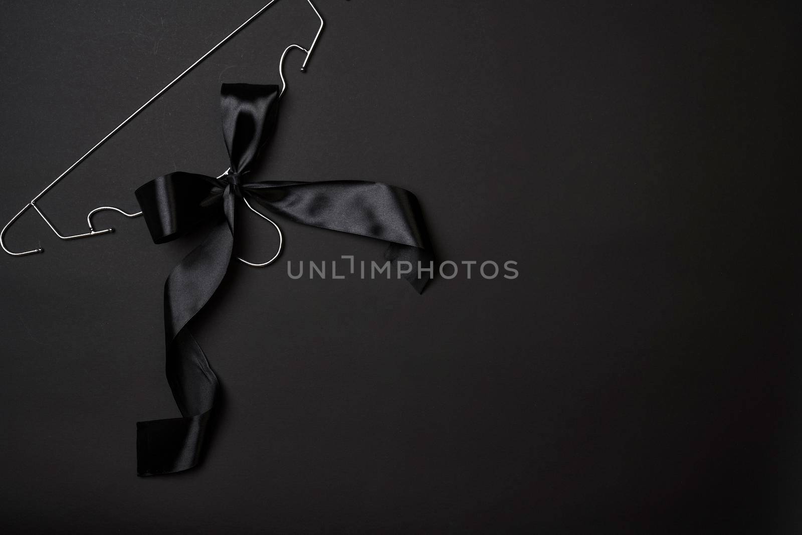 Black friday concept. Steel Cloth Hanger with black ribbon on dark background