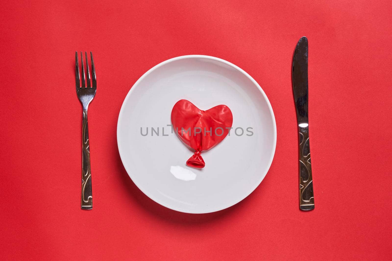Eating love. Heart shape balloon on the plate. Love eating