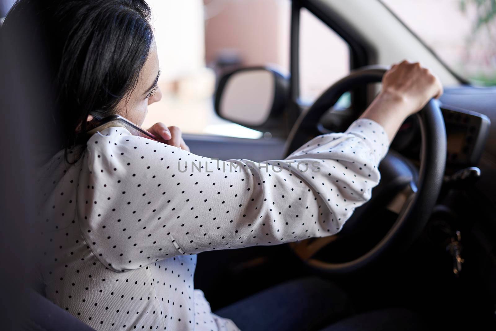 Unsafe driving. Young multiracial woman talking on the phone while driving. Distracted Driving. Female driving and talking on cellphone