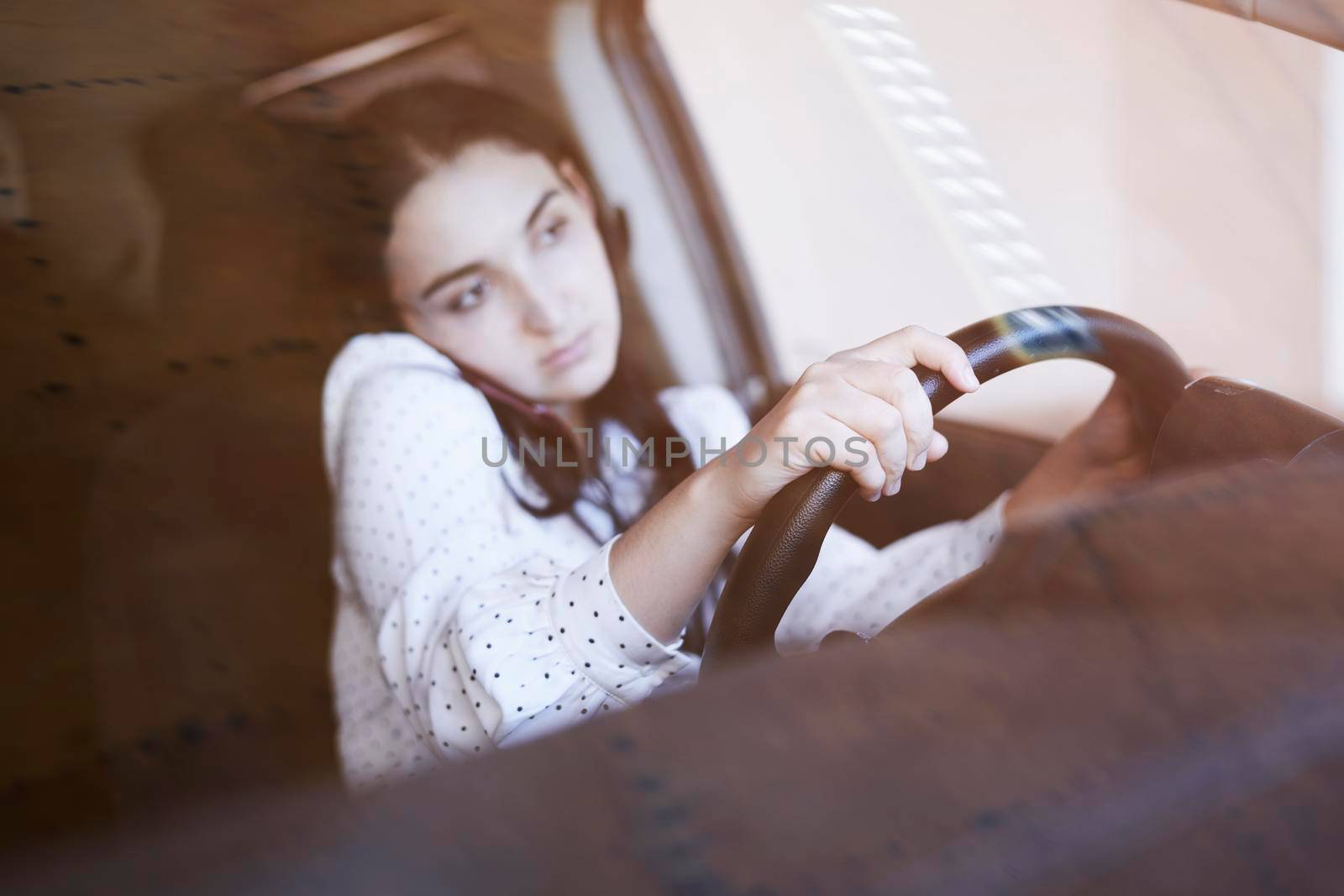 Unsafe driving. Young multiracial woman talking on the phone while driving. Distracted Driving. Female driving and talking on cellphone