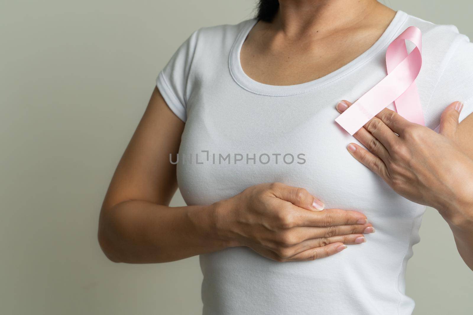 pink badge ribbon on woman chest to support breast cancer cause. breast cancer awareness concept