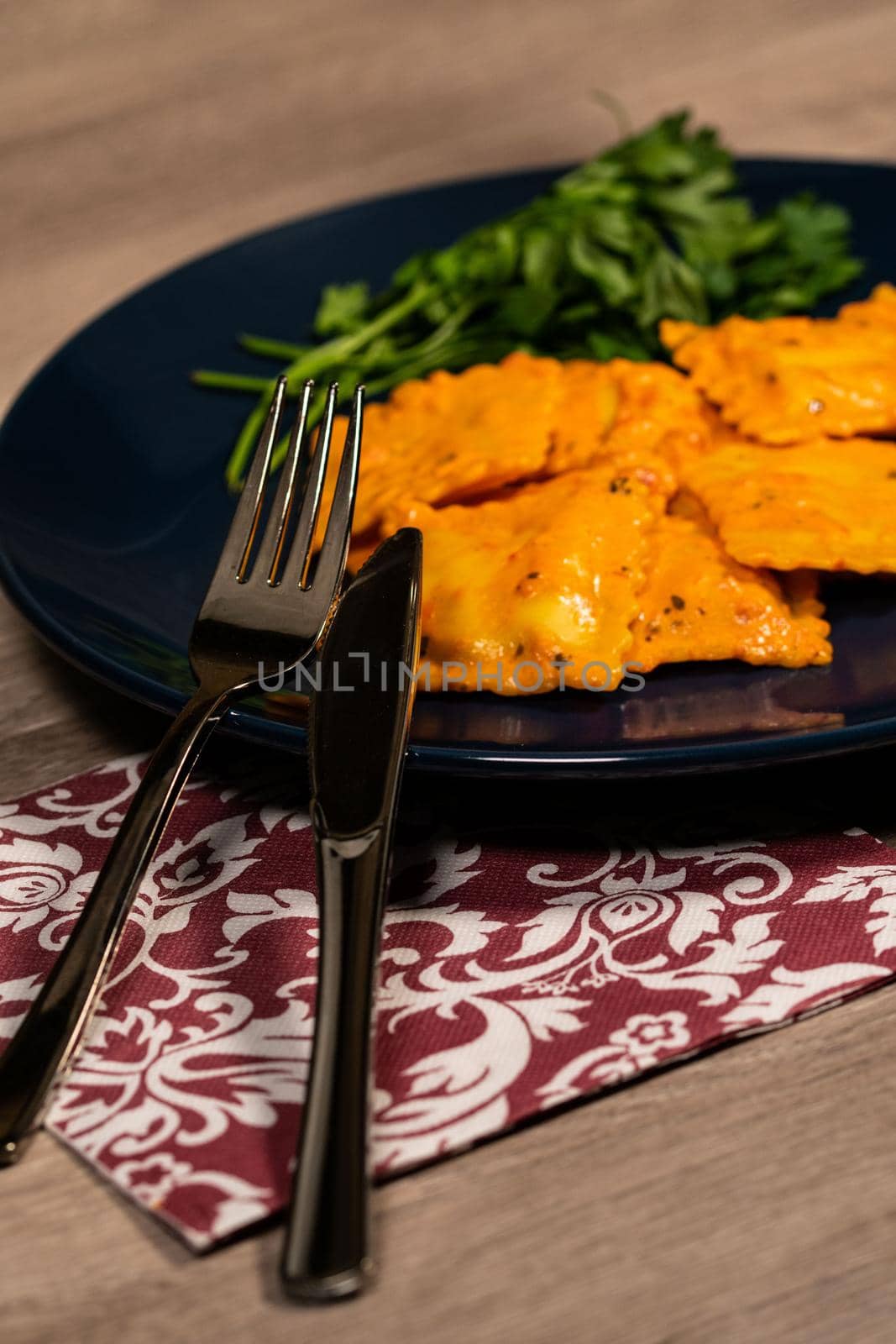 cutlery placed on a plate of ravioli by carfedeph