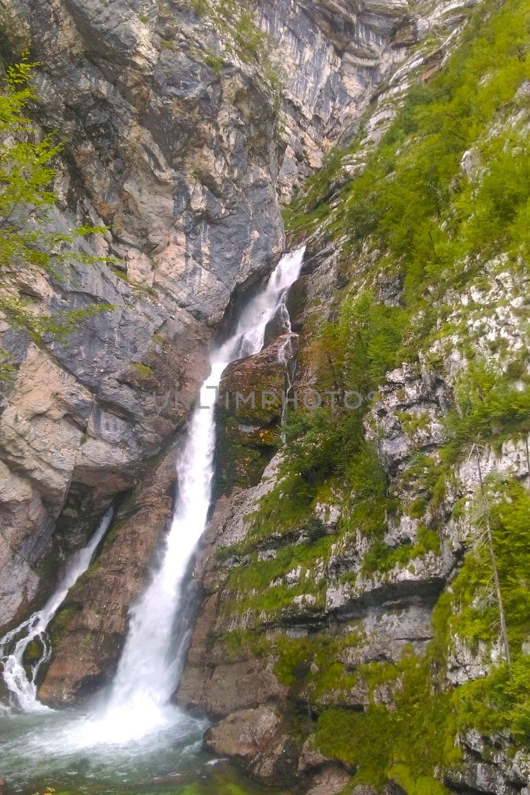 View of the waterfall in the mountains. Fresh pleasant breeze of water