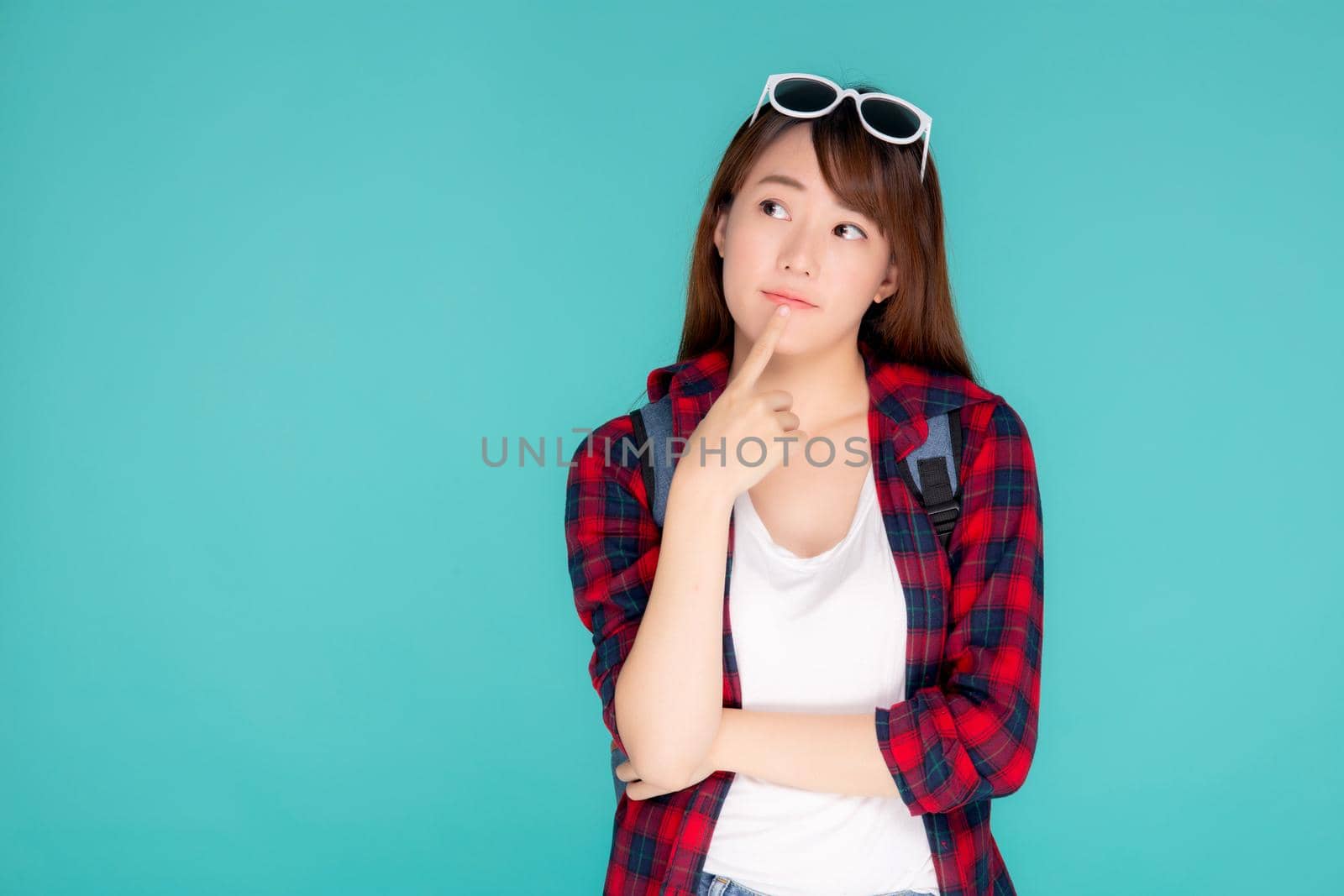 Beautiful portrait young asian woman wear sunglasses on head smile confident thinking and idea summer holiday isolated blue background, model girl fashion in vacation, travel concept. by nnudoo
