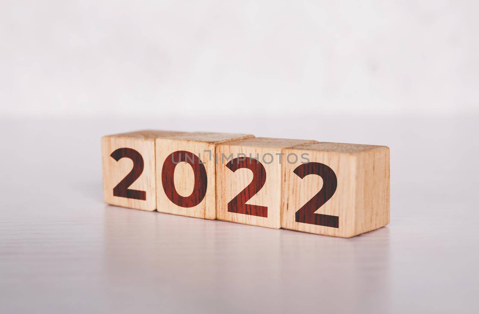 Cube wooden block with text year 2022, beginning and trend, calendar and time, determination target and planning for achievement, motivation and aspirations and improvement, business concepts. by nnudoo