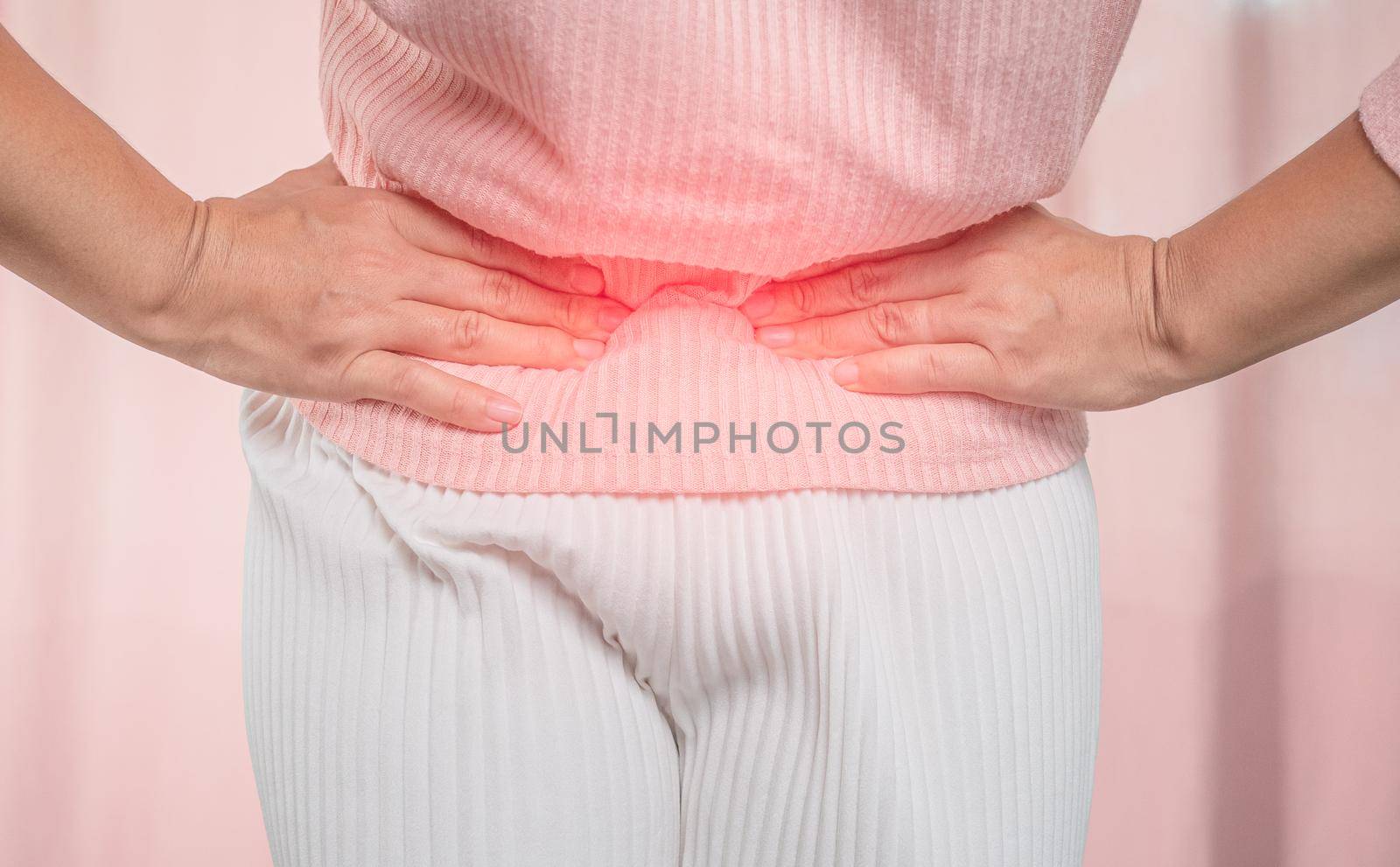 Young sick woman with hands holding her belly suffering menstrual period pain at home. Gynecology and female health concept.
