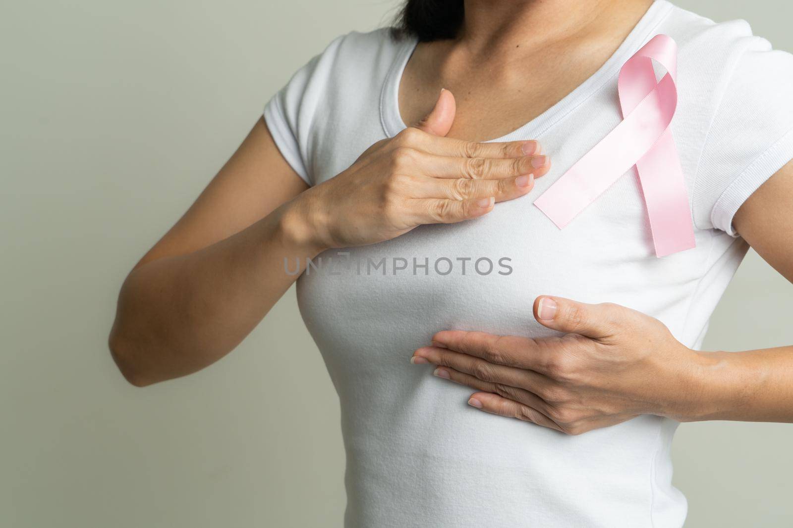 pink badge ribbon on woman chest to support breast cancer cause. breast cancer awareness concept