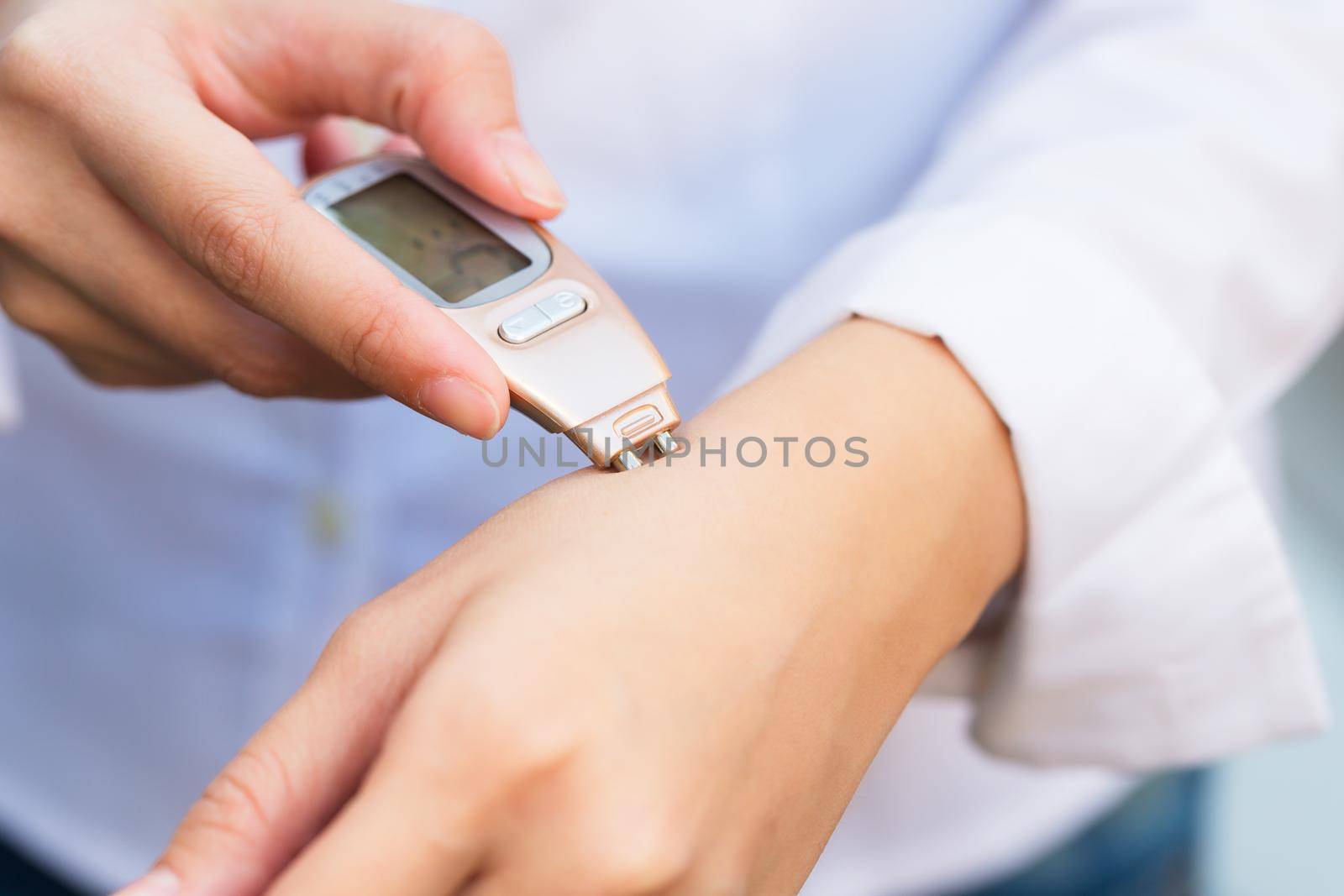 Close-up of person hand checking skin hand with Dermatoscope.