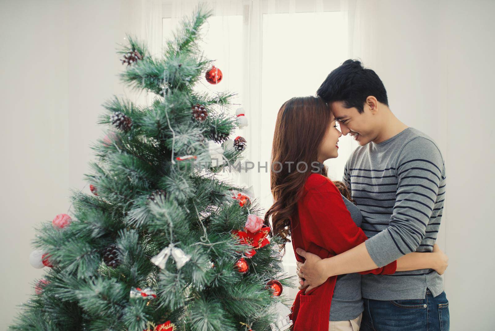 Christmas Asian Couple.Happy Smiling Family at home celebrating.New Year People