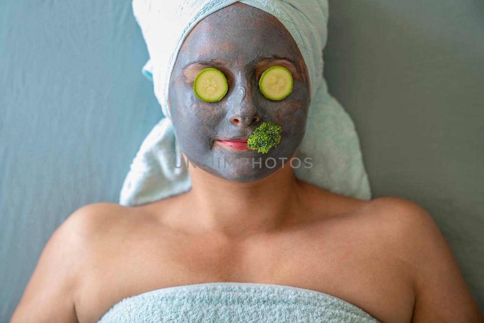 Young woman with cosmetic mask and natural vegetables on face. Concept of natural cosmetics
