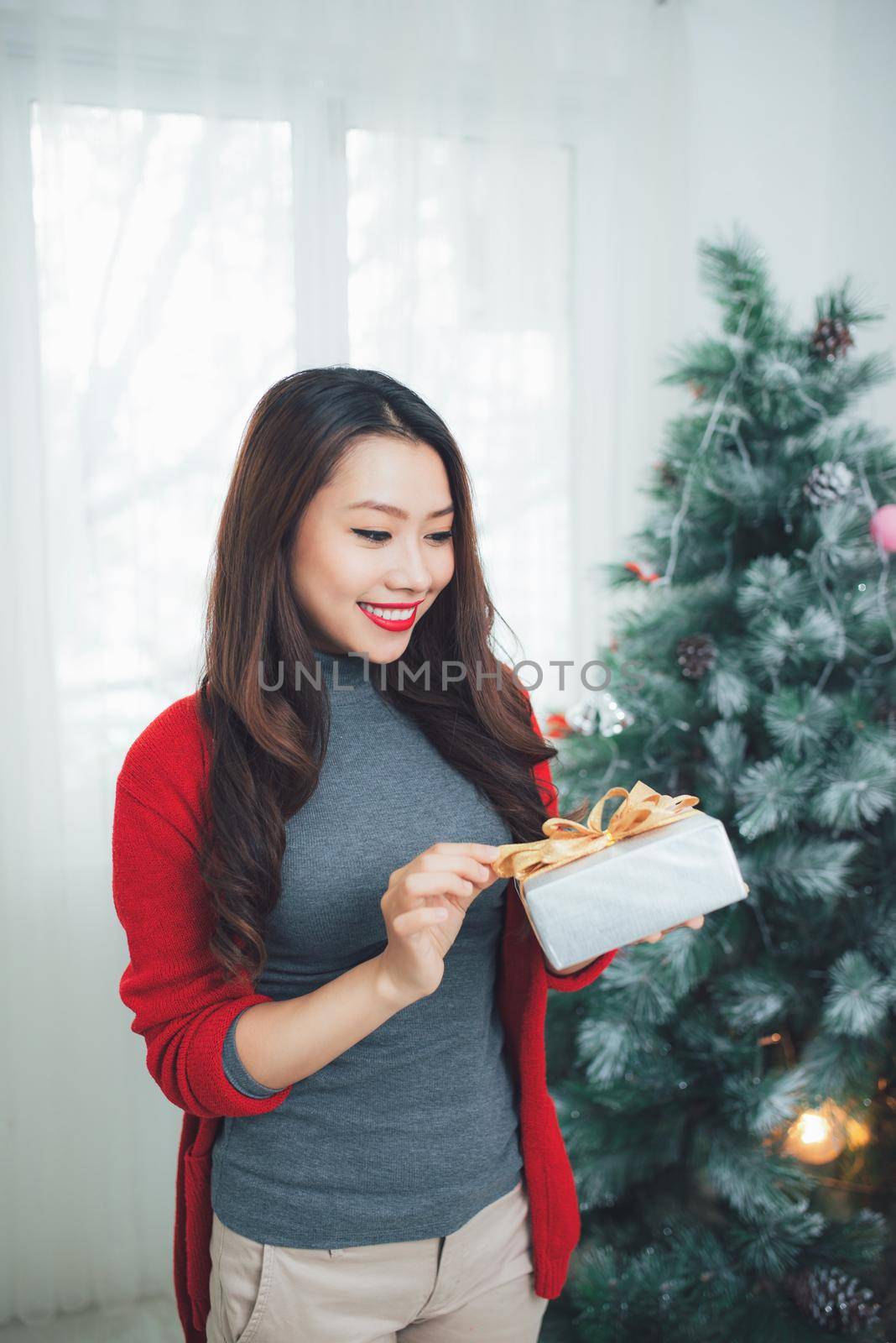 Christmas. Asian Pretty Woman  holding a gift celebrating New Year. by makidotvn