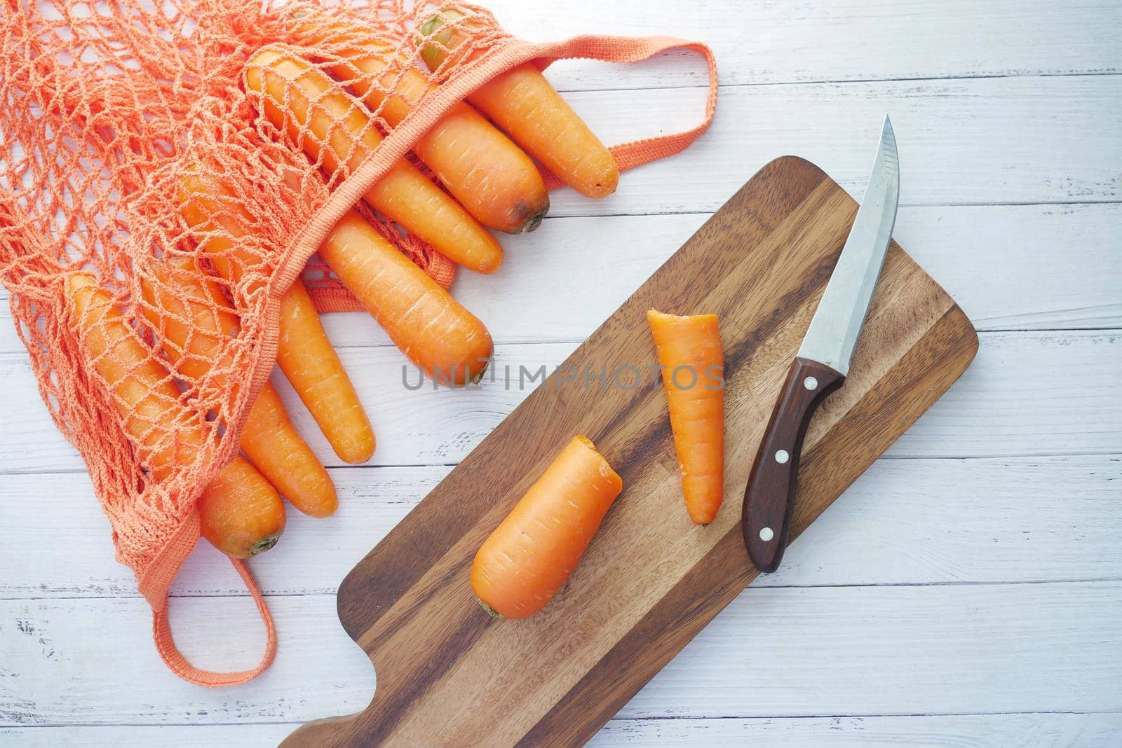 fresh carrots on chopping board on table .