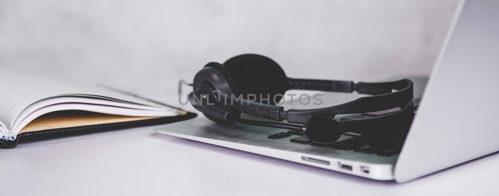 Laptop computer and headphone on desk, e-learning online, webinar for education and learning, seminar with notebook, video conference, headset for multimedia, course and classroom to internet.