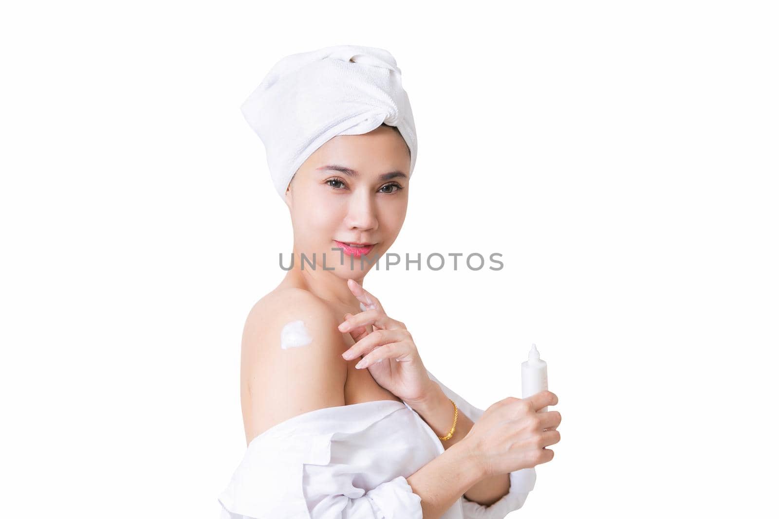 Beautiful girl in bath towel is applying cream on her shoulder. with clipping path by jayzynism