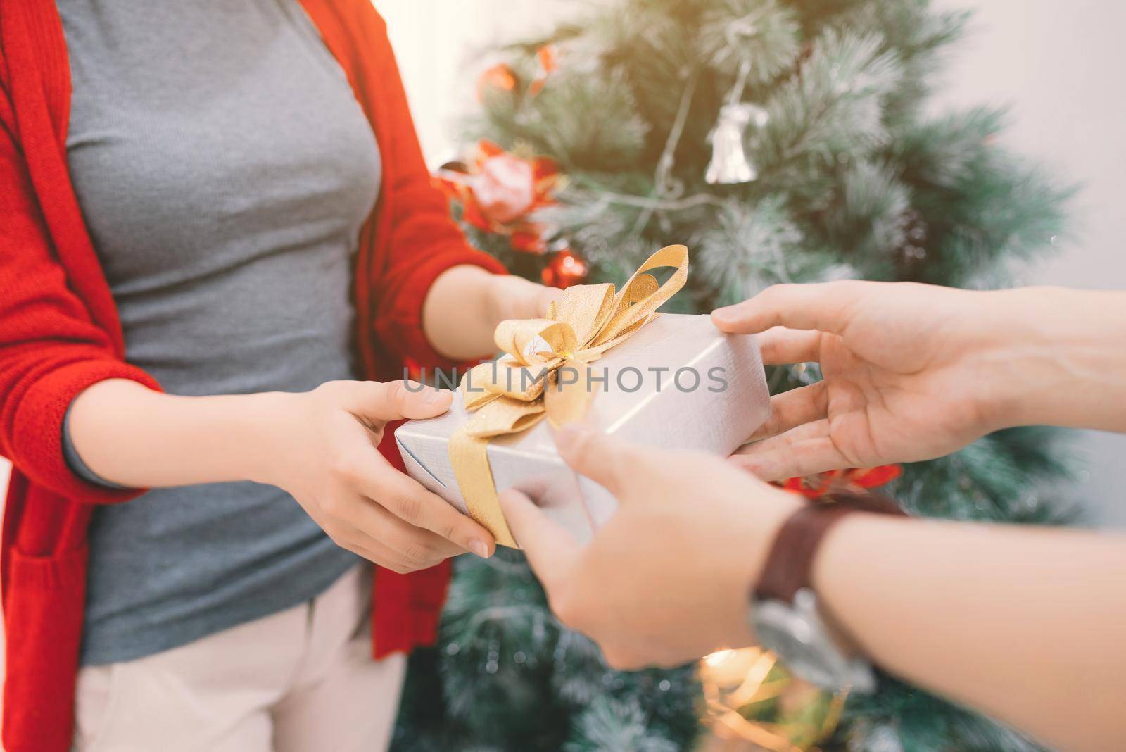 Christmas Asian Couple. A handsome man giving her girlfriend/wife a gift at home celebrating New Year People by makidotvn