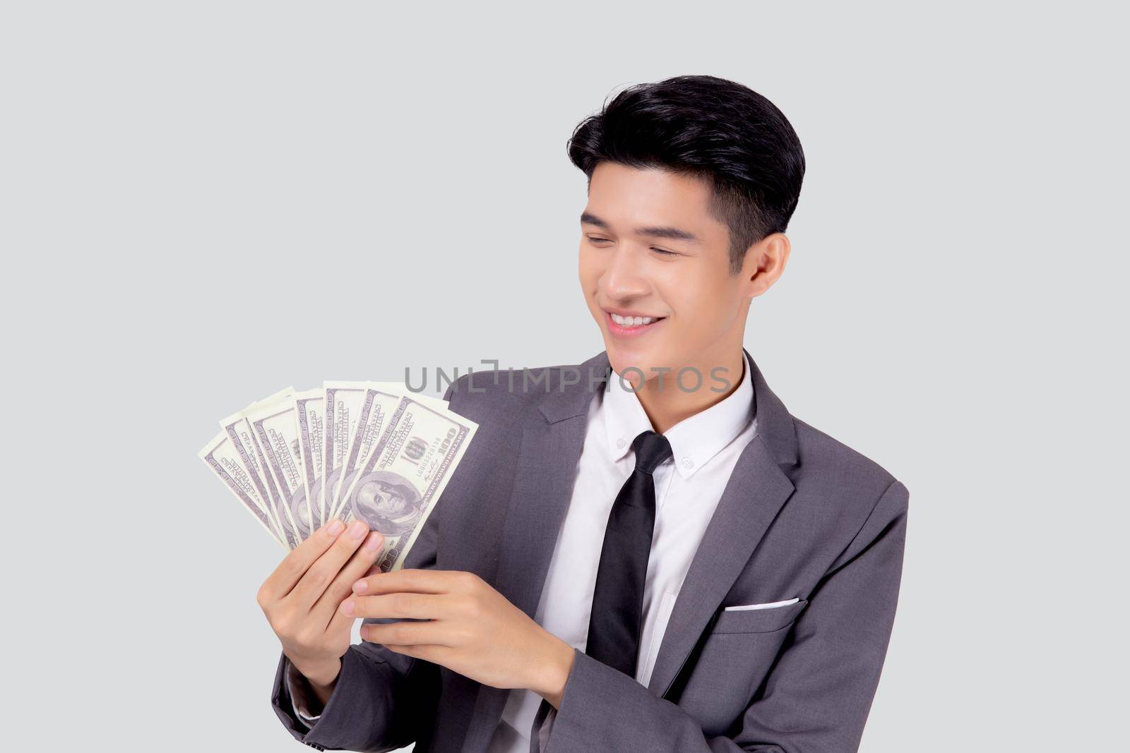 Young asian business man holding money dollar isolated on white background, businessman in suit holding banknote and success and excited with finance, savings and investment, income and spending. by nnudoo