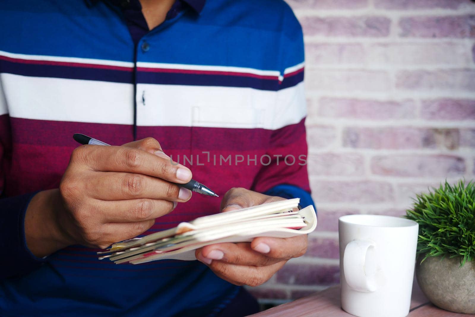 Close up of man hand writing on notepad