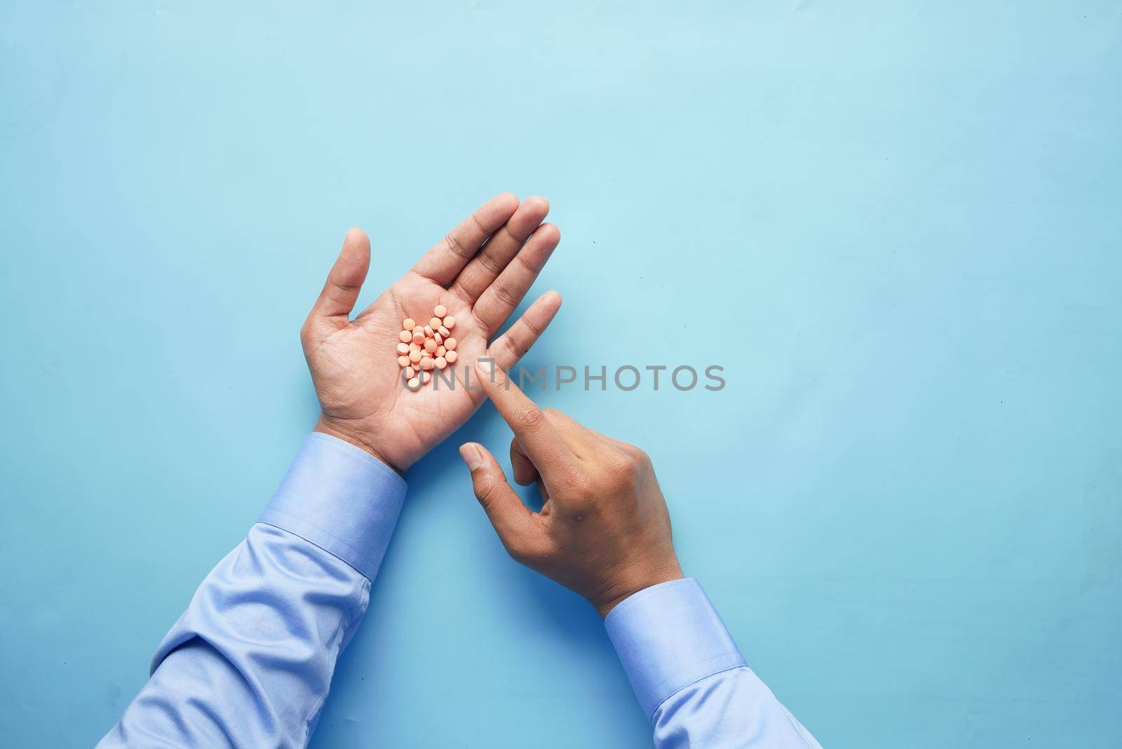 man's hand with pills spilled out of the container .