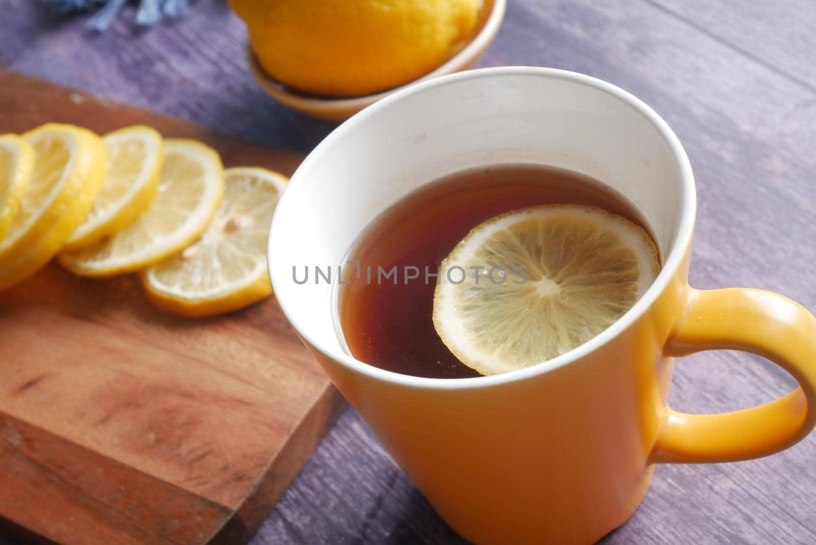 Close up of lemon tea on wooden background.