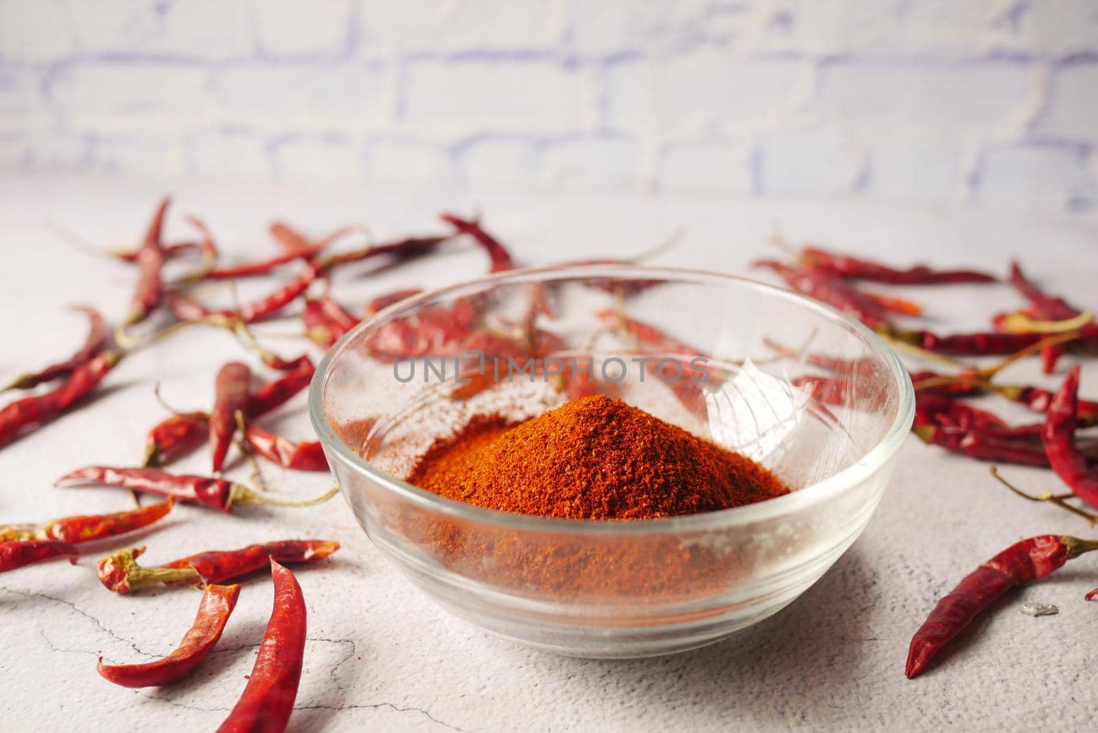 Chili powder and dried peppers on table background.
